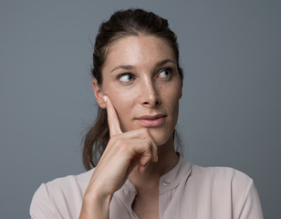 Confident woman thinking with hand on chin