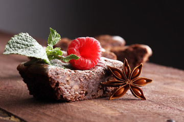 homemade chocolate brownies with raspberries and mint on wooden background
