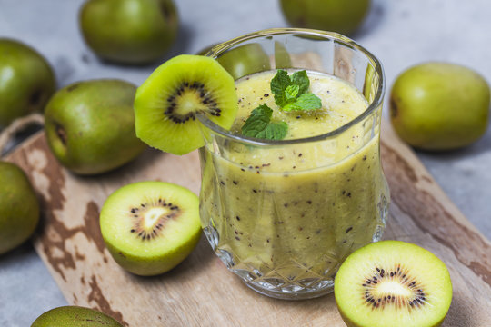glass of kiwi juice with fresh fruits on wooden table