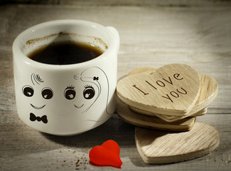 Close up cup of coffee with wedding couple design with red heart and writing i love you on wooden heart