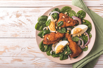 Spinach salad with egg, chiken, onion and pine nuts