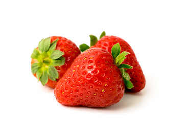 Three ripe strawberries on a white