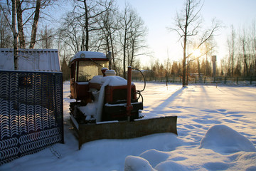 Tractor in the parking lot covered with snow