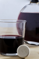the glass and the stopper, still life with a glass of red wine, a stopper and a bottle on the background. luxury. relax.