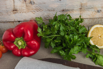 Assorted fresh healthy organic vegetables. Parsley, tomatoes red pepper and Lemon on top of wooden table.
