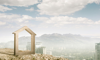 Conceptual image of concrete home sign on hill and natural lands