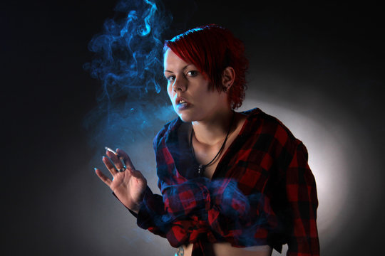 Eine junge Frau raucht Zigarette und blickt erschrocken