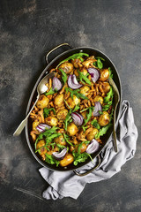 Oven baked new potato with mushrooms,onion and arugula.Top view.