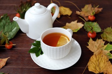 Tea with lemon on the table with autumn leaves  