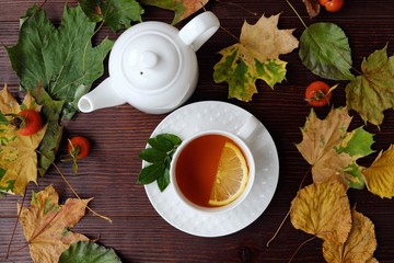 Tea with lemon on the table with autumn leaves 