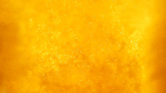 Bubbles floating in the amazing deep structured yellow gold liquid. Blurred background with dimension. 