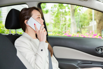 車で電話をする女性　ビジネス