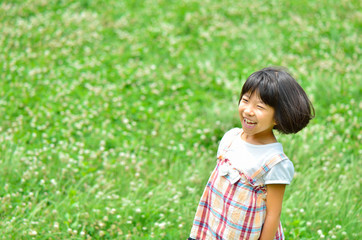 Fototapeta na wymiar 芝生広場で遊ぶ女の子