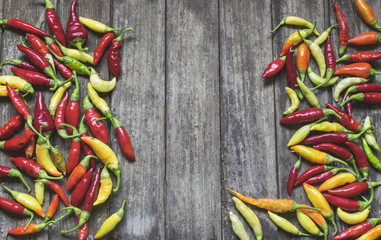 Colorful hot chilli peppers on wooden table with copy space