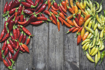 Colorful hot chilli peppers on wooden table with copy space