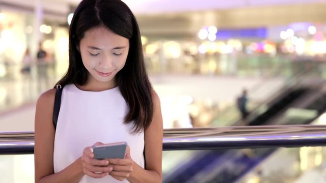 Young Woman use of mobile phone in shopping mall
