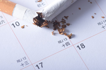 Broken cigarette on the calendar quit smoking concept. 