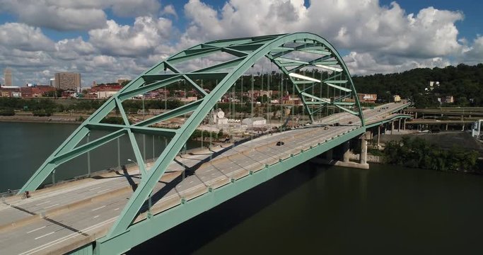 A daytime aerial establishing shot of traffic passing over the Birmingham Bridge over the Monongahela River near Pittsburgh, PA.  	