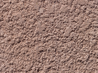 Fragment of the wall covered with coarse plaster of pink color