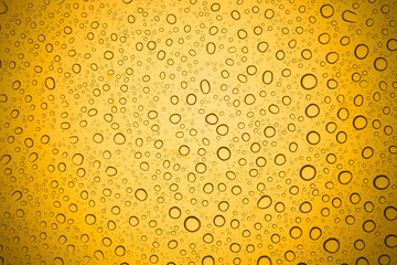 Water drops on yellow glass, Rain droplets on glass background.