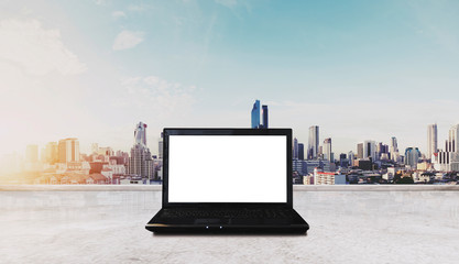 Computer laptop on white table, with Bangkok city view in sunrise background. Clipping path computer screen