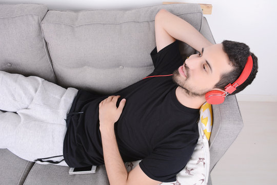 Man listening music on couch.