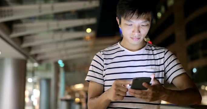 Man use of cellphone in city at night