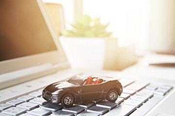Business, finance, saving money, banking or car loan concept : Miniature car model on computer laptop