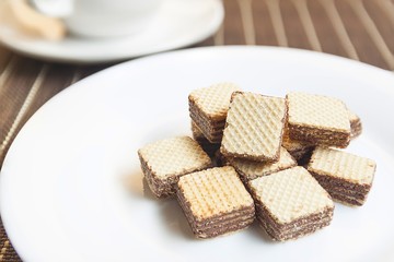 Wafers cubes with chocolate. on White plate
