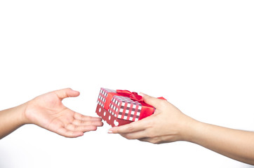 Closeup hands giving and receiving Christmas gift box wrapped with red ribbon isolated on white...