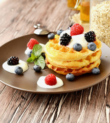 Belgian waffles with berries and honey selective focus