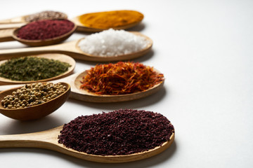 Spices in wooden spoons isolated on white background