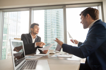 Two company leaders intensely discussing or arguing because of contract terms, can not come to agreement during negotiation, disagree with colleague opinion about business results. Dissatisfied client