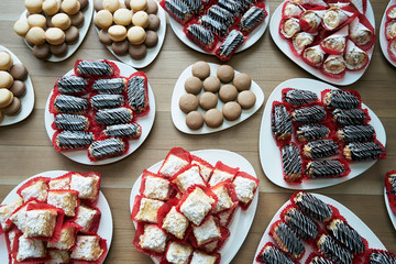 Table with various eclairs, cookies, tarts, cakes, cupcakes