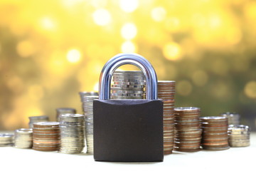 Coin money stack and lock, on gold light background. Saving and financial security concept.