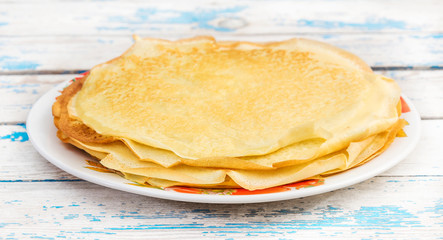 Plate with pancakes on the old blue table.