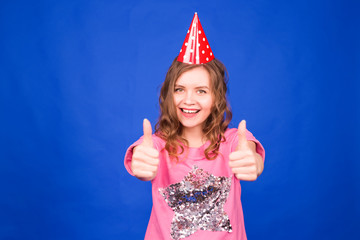 Woman in celebration cap showing thumbs up