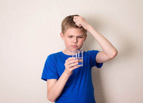 Boy observing a half full glass of water