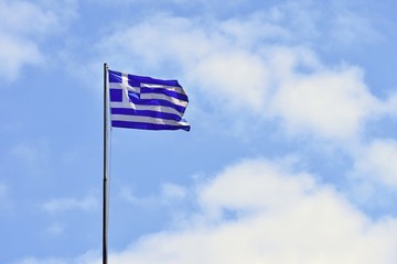 Flag of Greece Flying in Wind and Blue Sky. Summer background for travel and holidays. Greece Crete.