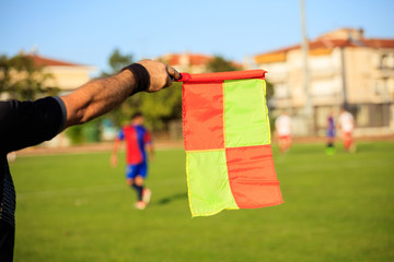 Soccer (football) referee assistant with flag on the field