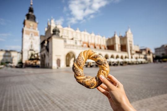 Holding prezel, traditional polish snack on the Market square in Krakow