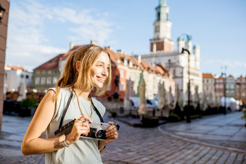 Porait of a young woman tourist traveling on the old Market sqaure in Poznan city during the morning light in Poland