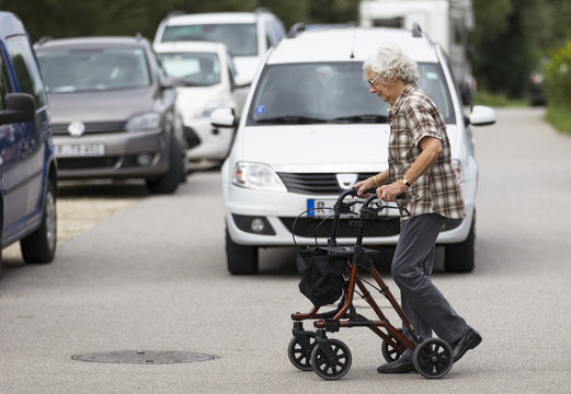 Seniorin am Rollator überquert die Straße