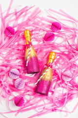 Pink and Gold Mini individual bottles for toasting of champagne with confetti and tinsel. Flat lay.  Holiday concept