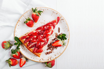 A piece of berry tart with Strawberry on wooden background with copy space
