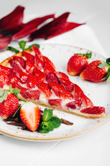 A piece of berry tart with Strawberry on wooden background
