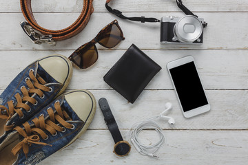 Above view of necessary items travel and technology background concept.Important accessory for travel and teenage or adult.Mix several objects on modern rustic white wooden home office desk.