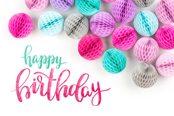 Honeycomb balls decorations border. Pink, lilac and turquoise paper pom pom on a white background. Flat lay.  Holiday concept