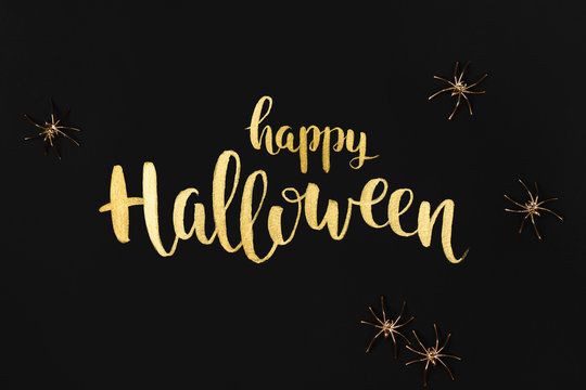 Halloween background with gold spiders. Hand drawn lettering.