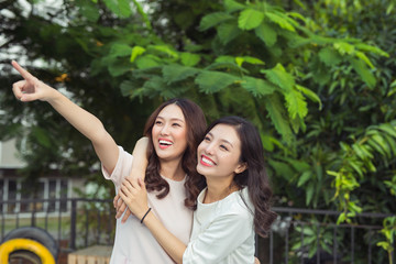 Happy friends or teenage girls having fun outdoors